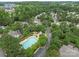 An aerial view shows a neighborhood with a swimming pool and lush green trees surrounding the homes at 4557 Panther Pl, Charlotte, NC 28269