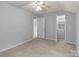 Carpeted bedroom features neutral walls, ceiling fan, and closet with built-in shelving and drawers at 4557 Panther Pl, Charlotte, NC 28269