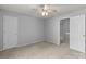 Carpeted bedroom features neutral walls, ceiling fan, and two doors at 4557 Panther Pl, Charlotte, NC 28269