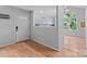 Bright entryway featuring wood floors, white door, and kitchen view at 4557 Panther Pl, Charlotte, NC 28269