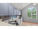 Bright kitchen featuring modern blue cabinets, a stylish backsplash, and a large window at 4557 Panther Pl, Charlotte, NC 28269