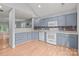 Open kitchen featuring light blue cabinets, white appliances, and a seamless transition to the living space at 4557 Panther Pl, Charlotte, NC 28269