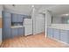 Spacious kitchen with light blue cabinets, white appliances, and a view of the adjacent living room at 4557 Panther Pl, Charlotte, NC 28269