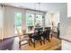 Light and airy dining room featuring wood table, upholstered chairs, and view to the backyard at 5130 Watersail Way, Clover, SC 29710