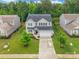 Two-story home with well-manicured lawn, long driveway, attached garage and mature trees in the front yard at 5130 Watersail Way, Clover, SC 29710