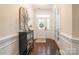 Inviting foyer with hardwood floors, glass paned door, and decorative table with ornate mirror above at 5130 Watersail Way, Clover, SC 29710