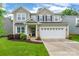 Charming two-story home with a two-car garage, manicured lawn, and inviting front entrance at 5130 Watersail Way, Clover, SC 29710