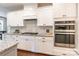 Modern kitchen features white cabinets, granite countertops, stainless steel appliances, and dark wood flooring at 5130 Watersail Way, Clover, SC 29710