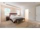 Bright main bedroom features a tray ceiling, neutral carpet, and a king bed with bedside tables at 5130 Watersail Way, Clover, SC 29710