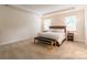 Bright main bedroom features a tray ceiling, neutral carpet, and a king bed with bedside tables at 5130 Watersail Way, Clover, SC 29710