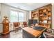 Home office with custom built-in shelving, large desk, and natural light from a nearby window at 5130 Watersail Way, Clover, SC 29710