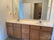 Bathroom featuring double sinks, white countertops, and wooden cabinets at 5476 Ives Nw St, Concord, NC 28027