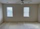 Spacious bedroom with carpet, ceiling fan and two large windows with blinds at 5476 Ives Nw St, Concord, NC 28027
