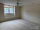 Carpeted bedroom with a window seat and ceiling fan, offering a bright and airy space at 5476 Ives Nw St, Concord, NC 28027