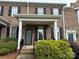 Inviting two-story townhouse features brick facade, black shutters, and lush landscaping at 5476 Ives Nw St, Concord, NC 28027
