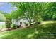 Beautiful backyard with a patio, lush green lawn, and surrounding trees for privacy at 6033 Edinmeadow Ln, Charlotte, NC 28269