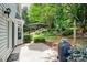 Charming backyard featuring a patio, lush landscaping, and mature trees for shade at 6033 Edinmeadow Ln, Charlotte, NC 28269