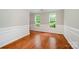 Hardwood floors and decorative trim in a well-lit dining room with large windows at 6033 Edinmeadow Ln, Charlotte, NC 28269