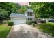 Two-story home with driveway, two-car garage, landscaped lawn and mature trees in a pleasant setting at 6033 Edinmeadow Ln, Charlotte, NC 28269