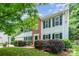 Charming two-story home with landscaped yard, brick accent, black shutters, and vibrant green foliage at 6033 Edinmeadow Ln, Charlotte, NC 28269
