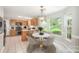 Bright eat-in kitchen featuring stainless appliances, wood cabinets, and a modern marble table at 6033 Edinmeadow Ln, Charlotte, NC 28269