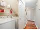 Practical laundry area with shelving for storage, adjacent to the hallway and staircase at 6033 Edinmeadow Ln, Charlotte, NC 28269