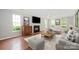 Bright living room with a cozy fireplace, plush furniture, hardwood floors, and natural light at 6033 Edinmeadow Ln, Charlotte, NC 28269