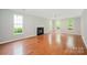 Spacious living room with a fireplace, hardwood floors, and large windows offering natural light at 6033 Edinmeadow Ln, Charlotte, NC 28269