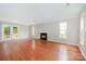 Bright living room with hardwood floors, a fireplace, and large windows for ample natural light at 6033 Edinmeadow Ln, Charlotte, NC 28269