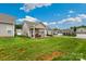 Home's backyard showing covered patio, green lawn and neighborhood view at 620 River Birch Dr, Salisbury, NC 28146