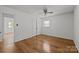 Empty bedroom features hardwood floors, a ceiling fan, and a window that provides ample natural light at 6231 Coach Hill Ln, Charlotte, NC 28212