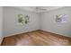 Bright bedroom with hardwood floors, a ceiling fan, and two windows that provide ample natural light at 6231 Coach Hill Ln, Charlotte, NC 28212