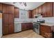 Kitchen with dark wood cabinets and stainless steel appliances at 6231 Coach Hill Ln, Charlotte, NC 28212