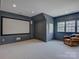 Comfortable bonus room featuring a blank projector screen, leather chair, and recessed lighting at 628 Bracket St, Fort Mill, SC 29708