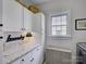 Well-organized laundry room with white cabinets, granite countertop, and woven hamper at 628 Bracket St, Fort Mill, SC 29708