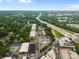 Aerial view showing neighborhood streets, green trees, nearby highway, and commercial buildings at 630 Calvert St # 111, Charlotte, NC 28208