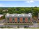 Brick apartment building with balconies, lush greenery, and ample parking at 630 Calvert St # 111, Charlotte, NC 28208