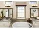Bright bathroom featuring a large bathtub, dual vanities, and a large window at 6510 Honeymeade Cir, Charlotte, NC 28277