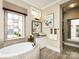 Bright bathroom showcasing a soaking tub, vanity, and view to the exterior at 6510 Honeymeade Cir, Charlotte, NC 28277