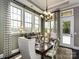 An elegant dining room with large windows and a stylish chandelier at 6510 Honeymeade Cir, Charlotte, NC 28277