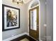Inviting foyer with a modern light fixture, hardwood floors, and a glass-panel wooden front door at 6510 Honeymeade Cir, Charlotte, NC 28277