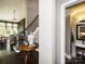 Hallway with hardwood floors and a staircase in view, leading to an adjacent living room and powder room at 6510 Honeymeade Cir, Charlotte, NC 28277