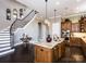 Open-concept kitchen with a large island, modern appliances, a staircase, and hardwood floors at 6510 Honeymeade Cir, Charlotte, NC 28277