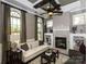 Elegant living room with a stone fireplace, large windows, and comfortable seating arrangements at 6510 Honeymeade Cir, Charlotte, NC 28277