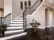 Elegant staircase featuring dark wood floors and a white riser staircase at 6510 Honeymeade Cir, Charlotte, NC 28277