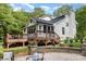 Lovely outdoor living space featuring a deck, outdoor stone fireplace and lush landscaping at 6639 Camp Creek Rd, Lancaster, SC 29720