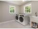 Laundry room with modern washer and dryer, a utility sink, and natural light from two windows at 6639 Camp Creek Rd, Lancaster, SC 29720