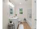 Bright bathroom featuring a single vanity, a tub, a window and wood-look vinyl floors at 818 Stowe Ln, Gastonia, NC 28056