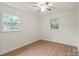 Bright bedroom featuring light walls, light wood floors, and two windows at 818 Stowe Ln, Gastonia, NC 28056