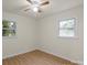 An empty bedroom featuring light walls, light wood floors, and two windows at 818 Stowe Ln, Gastonia, NC 28056